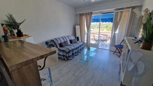 un salon avec un canapé et une table dans l'établissement Charmant petit studio à 100 m de la mer, à Cagnes-sur-Mer
