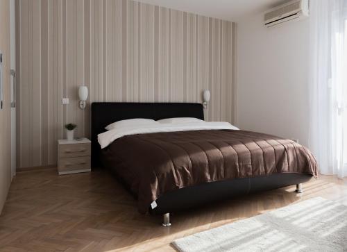 a bedroom with a large bed with a wooden floor at Apartment Admiral in Belgrade