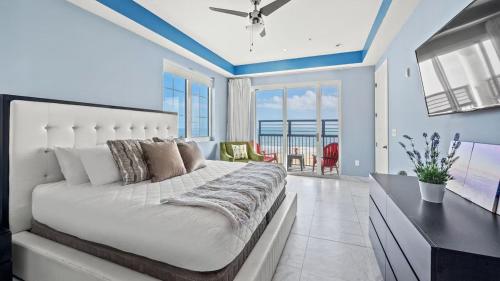 a bedroom with a large white bed with a view of the ocean at Bali Bay Resort in Myrtle Beach