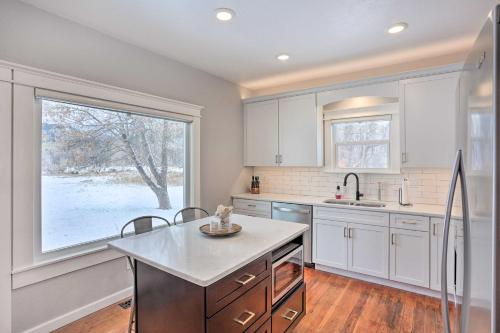 a kitchen with white cabinets and a large window at Home Near Downtown and Spearfish Canyon! in Spearfish