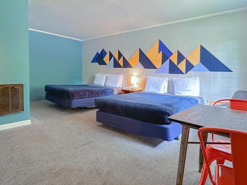 a hotel room with two beds and a table and chairs at The Wanderoo Lodge in Eureka Springs