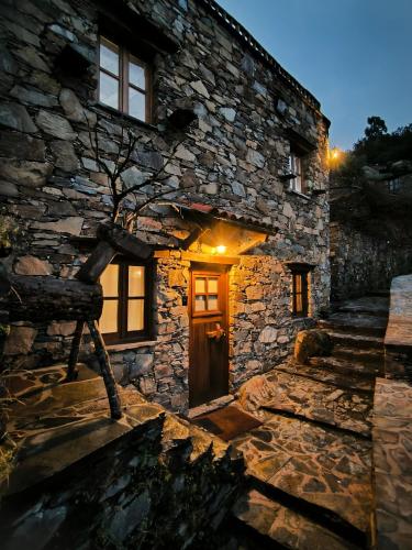 a stone house with a tree in front of it at Cantinho do Talasnal in Talasnal
