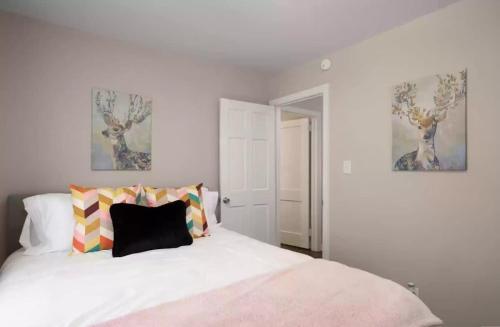 a bedroom with a white bed and two paintings on the wall at Spacious 4BR Home with 2 Baths & Fun Game Room in Birmingham