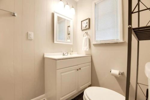 a white bathroom with a sink and a mirror at Spacious 4BR Home with 2 Baths & Fun Game Room in Birmingham
