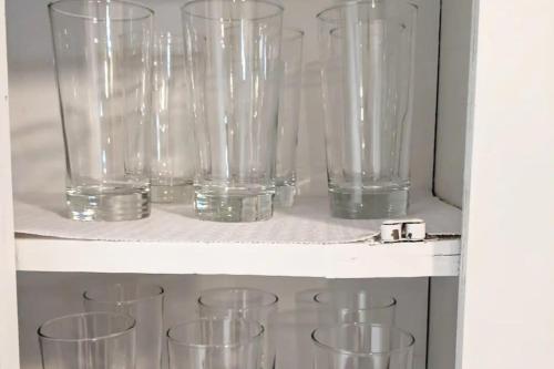 a row of glasses sitting on a shelf at Spacious 4BR Home with 2 Baths & Fun Game Room in Birmingham