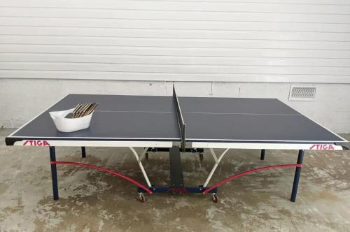 a ping pong table with a tennis racket on it at Spacious 4BR Home with 2 Baths & Fun Game Room in Birmingham