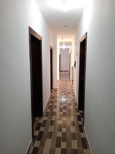 an empty hallway with doors and a checkered floor at Petra Planet in Wadi Musa