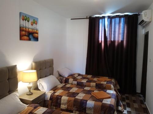 a bedroom with two beds and a window at Petra Planet in Wadi Musa