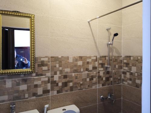a person taking a picture in a mirror in a bathroom at Petra Planet in Wadi Musa