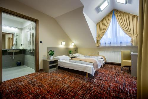 Schlafzimmer im Dachgeschoss mit 2 Betten und einem Badezimmer in der Unterkunft Pensjonat Kanion in Szklarska Poręba