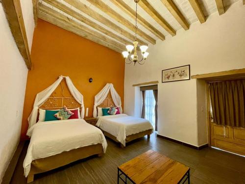 a bedroom with two beds and a table at Hacienda Santa Maria Regla in Huasca de Ocampo