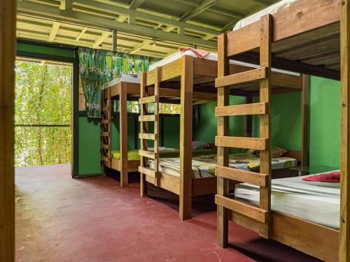 a room with three bunk beds and a window at Corcovado Adventures in Drake