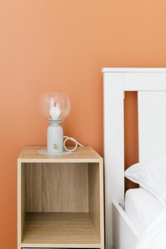 - une table de chevet avec une lampe à côté d'un lit dans l'établissement HELIANTHE - Cosy et spacieux refait à neuf tout confort, à Saint-Étienne