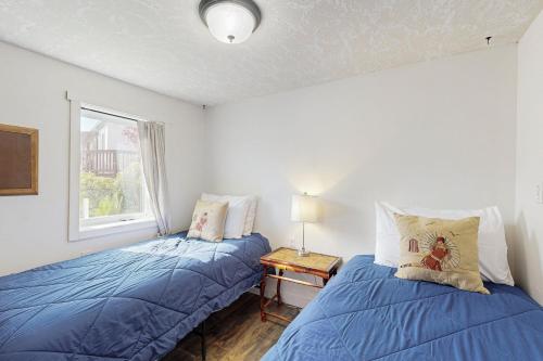 Un dormitorio con dos camas y una ventana. en Mermaid Crossing, en Netarts