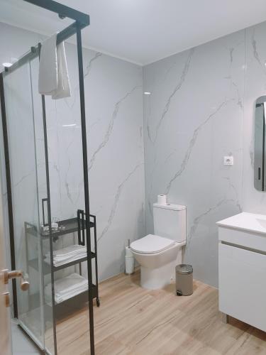 a bathroom with a toilet and a glass shower at Casas dos Senadores by Vale do Zêzere Hotel in Manteigas