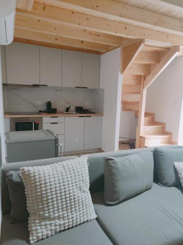 a living room with a blue couch and a kitchen at Casas dos Senadores by Vale do Zêzere Hotel in Manteigas