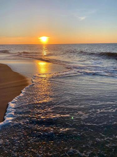 a sunset on the beach with the tide coming in at The Maddox Inn in Chincoteague