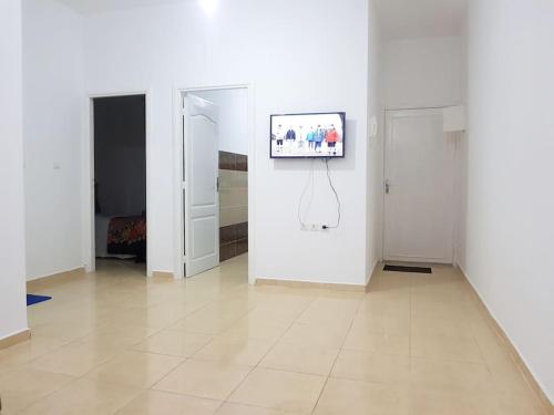 a white room with a television on a wall at Appartement des vacances à Bades près de corniche in Al Hoceïma