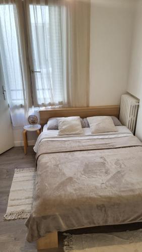 Cette chambre comprend un grand lit et des fenêtres. dans l'établissement Apparemment parisien, à Paris