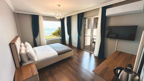 ein Schlafzimmer mit einem Bett und Meerblick in der Unterkunft Çamlıca Hotel in Pelitli