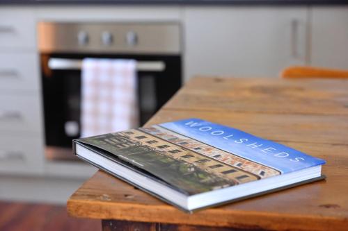 a book sitting on top of a wooden table at The Jetty Hut - Lake Frontage Barmera Riverland in Barmera