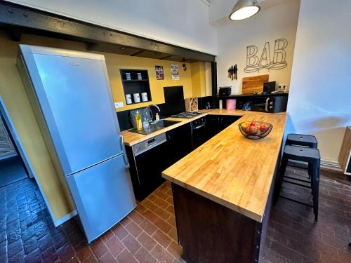 une cuisine avec un réfrigérateur et un comptoir en bois dans l'établissement Le Loft Rouen Centre, à Rouen