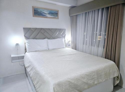 a bedroom with a large white bed with a window at Persimmon Studios - Studio Unit- 16th Floor - 1641 in Cebu City