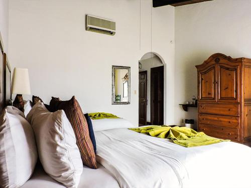 a bedroom with two white beds and a dresser at Hacienda Bajamar in Sonorabampo