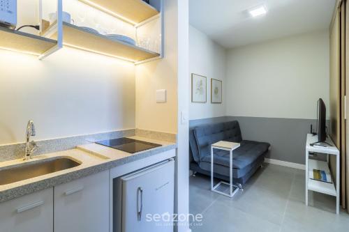 a kitchen with a sink and a couch in a room at EVAs - Apartamentos charmosos com vista mar em Floripa in Florianópolis