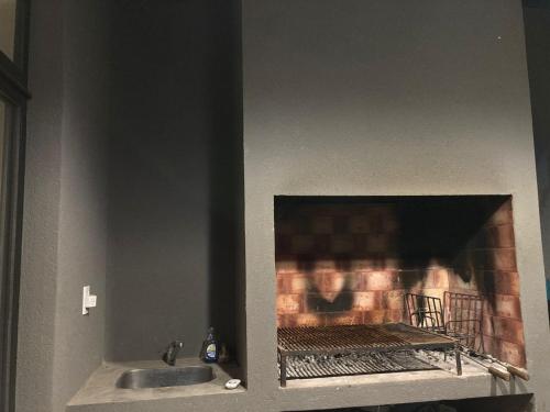 a kitchen with a fireplace with a sink and a sink at Casa Rafael in La Plata