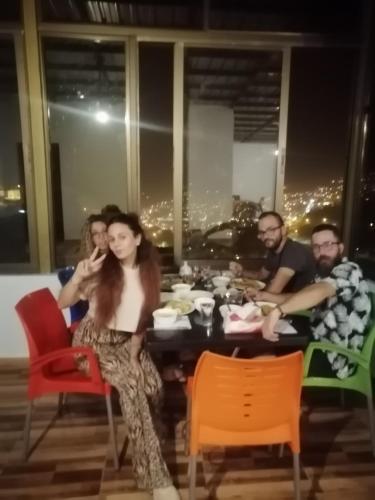 a group of people sitting around a table with food at Petra Planet in Wadi Musa