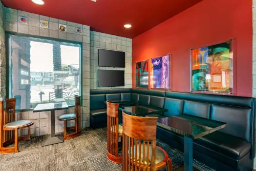 a restaurant with a bar with red walls and chairs at Best Western Plus Sundial in Scottsdale