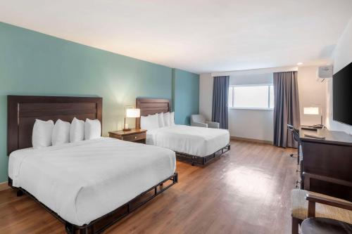 a hotel room with two beds and a desk at Best Western At Ventura Pier in Ventura