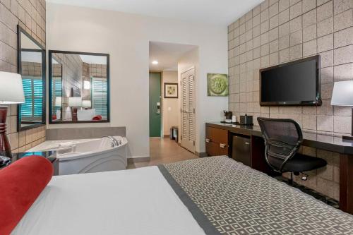 a hotel room with a bed and a tub and a tv at Best Western Plus Sundial in Scottsdale