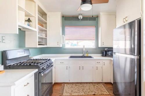 a kitchen with white cabinets and a stainless steel refrigerator at Joshua Tree King&Queen Beds 10mins to JTNP New in Twentynine Palms