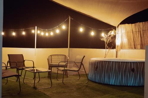 a room with chairs and a table and lights at Apartment with private rooftop 450 m from the beach in Flic-en-Flac