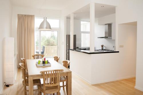 a kitchen and dining room with a table and chairs at Casa Del Cisne in Zandvoort