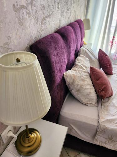 a lamp on a table next to a bed with pillows at Jolie appartement in Kenitra