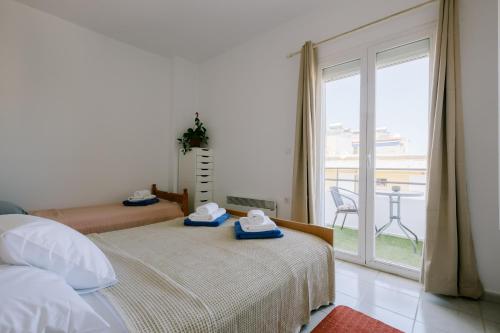 a bedroom with two beds and a large window at Stadium Apt in Kos