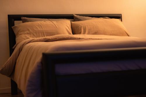 a bed with white sheets and pillows at Apartment with private rooftop 450 m from the beach in Flic-en-Flac
