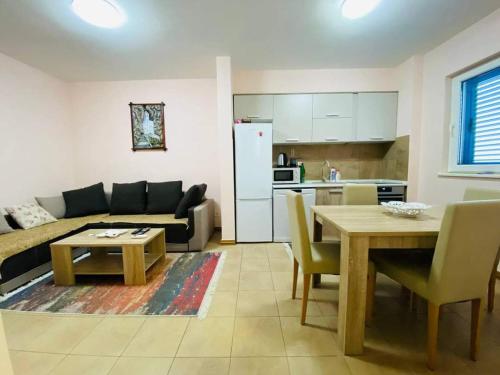 a living room with a couch and a table and a kitchen at Apartman Cristo Becici in Rafailovici