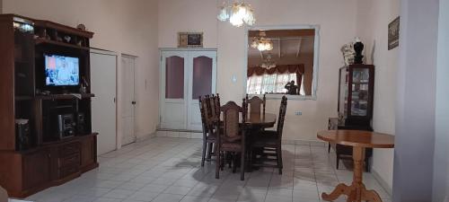 a dining room with a table and chairs and a television at Casa Familiar "Chiqui" in Cochabamba