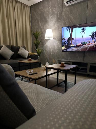 a living room with a couch and a flat screen tv at سُكْنَى خصوصية عائلية بفخامة متناهية وبدخول ذكي النفل in Riyadh