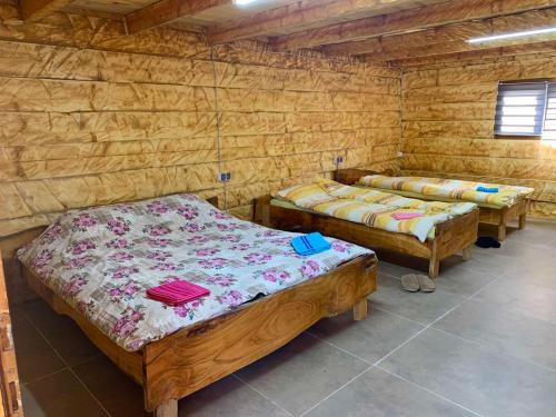 two beds in a room with wooden walls at CAMP Odmaraliste PURISIC in Plav