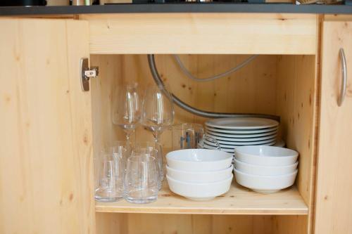 a cabinet with glasses and bowls and plates at Tiny House Nature 14 - Green Tiny Village Harz in Osterode