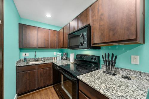 a kitchen with wooden cabinets and a black stove top oven at Central 1BR with Free Parking Near Med Center & NRG Stadium in Houston