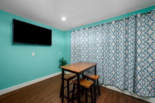 a dining room with a table and a television on a wall at Central 1BR with Free Parking Near Med Center & NRG Stadium in Houston