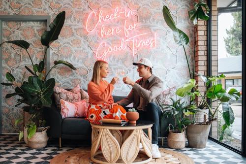 a man and woman sitting on a couch in a living room at Hara House in Bright