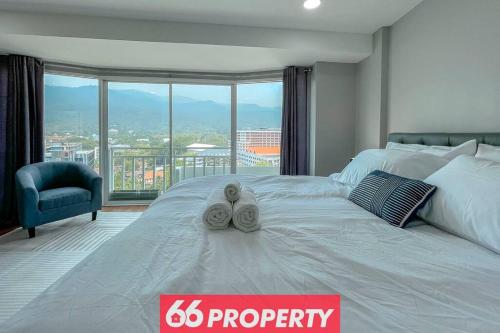 1 cama blanca grande con 2 toallas encima en Stunning Mountain View Duplex w Full Kitchen - Walk to Nimman, en Chiang Mai
