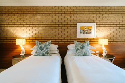 two beds in a room with two lamps at Hara House in Bright